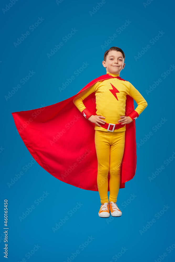 Confident superhero child in flying cape
