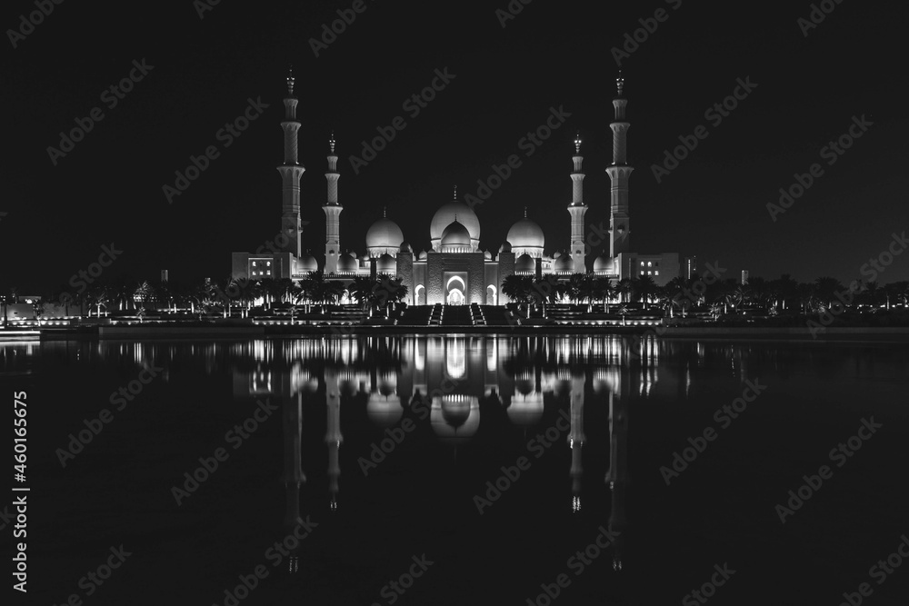 Naklejka premium Famous Grand Mosque in Abu Dhabi, United Arab Emirates at night with a reflection in the pool in black and white