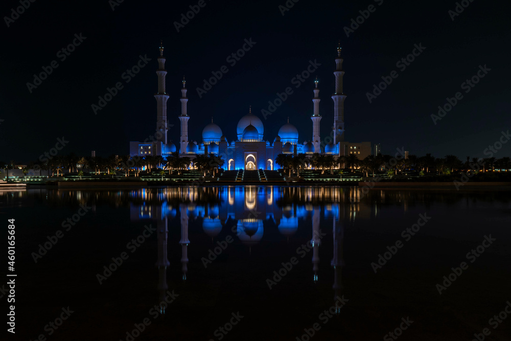 Famous Grand Mosque in Abu Dhabi, United Arab Emirates at night with a reflection in the pool