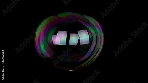 large soap bubble isolated on black background slow motion