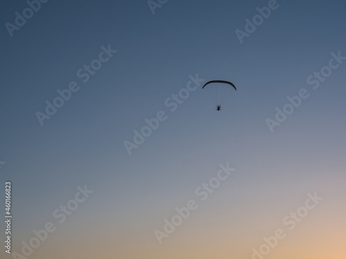 Nice sunset with motor paraglider flying in beautiful sky