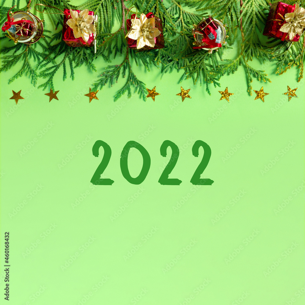 Red gift boxes with gold braid and branches of New Year tree on green paper. Creative christmas background with copy space for text. Red gift boxes with gold braid and branches of New Year tree on green paper. Creative christmas background with copy space for text.