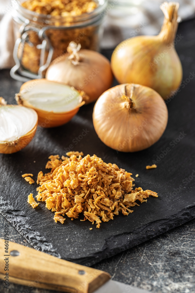 Pieces of fried onions on cutting board. Pieces of fried onions on cutting board.