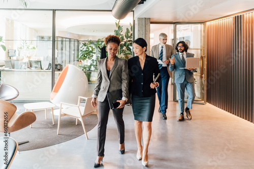 Italy, Business people walking in creative studio photo