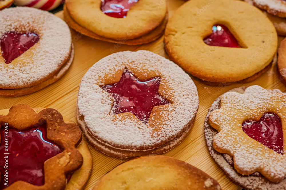 Homemade Christmas cookies with raspberry jam. Traditional Linzer cookies on a dark table, copy space