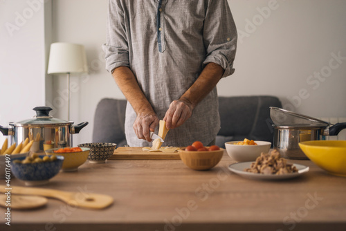 adult man with vitiligo, preparing a pasta salad