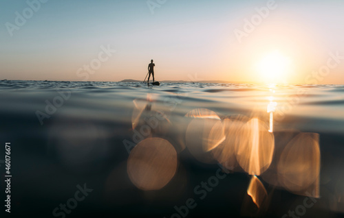 Bilde på lerret Silhouette of a man paddleboarding, copy space