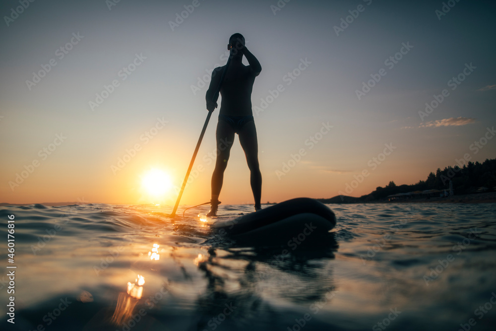 Silhouette of a man practicing paddleboard