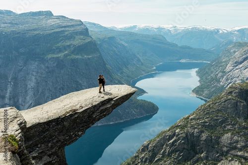 A happy couple standing on the Trolltunga cliff, Vestland county, Norway