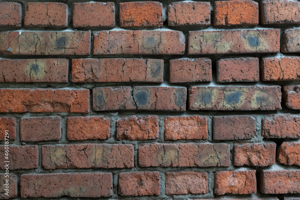 Weathered dark brick background. Close-up view of old molded red brick wall covered with cracks and scratches. Copy space for your text and decorations. Demolition theme. Weathered dark brick background. Close-up view of old molded red brick wall covered with cracks and scratches. Copy space for your text and decorations. Demolition theme.