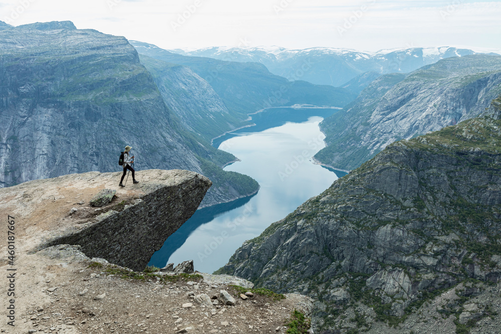 A young woman walk on Trolltunga cliff, Vestland county, Norway