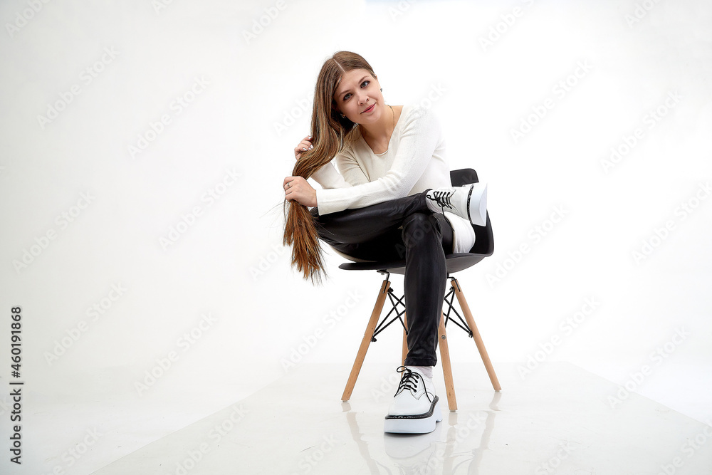 Fototapeta premium Beautiful young woman or girl wearing casual clothes on white background. Young female model posing during photo shoot