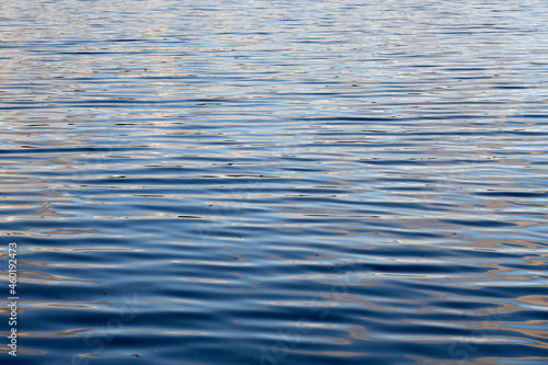 Light ripples of waves on the surface of the lake water.