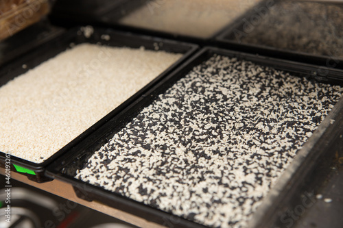 Plastic containers with white and black sesame seeds