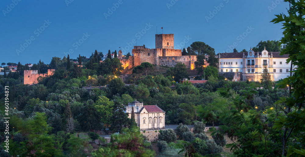 Panoramic view at dusk of the monumental complex of Tomar Castle, Convent of Christ and the Chapel of Nossa Senhora da Conceição, in the city of Tomar, Portugal.