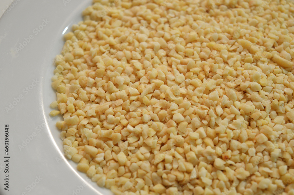 Food crumbs - Cloeup of some small pieces of almonds in a plate looking like cheese - Cereals, Dried fruits and Nuts Food crumbs - Cloeup of some small pieces of almonds in a plate looking like cheese - Cereals, Dried fruits and Nuts