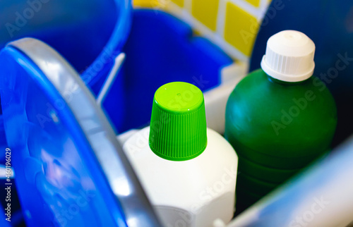 Produtos desinfetantes. Duas garrafas de produtos de limpeza em foto de perto que estão dentro de um carrinho de limpeza de cor azul. Higiene, Limpeza doméstica, água sanitária, desinfetante. photo