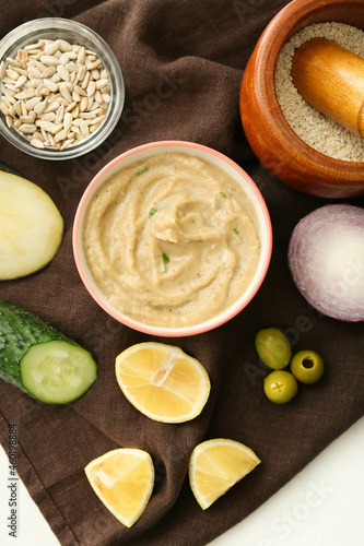 Bowl with tasty baba ghanoush and fresh ingredients on napkin