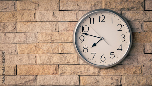 White classic clock hang on brick wall background.
