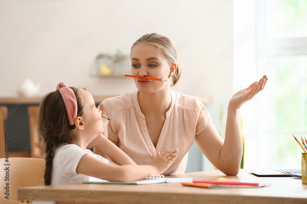 Little girl with her mother doing lessons at home Little girl with her mother doing lessons at home
