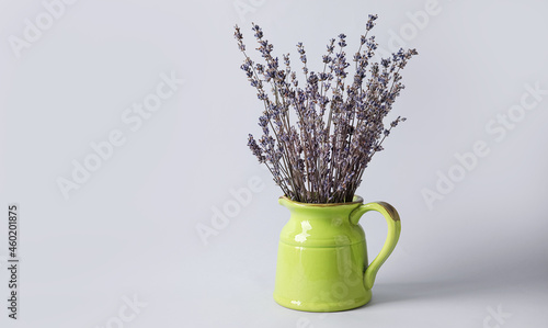 Jug with beautiful lavender flowers on grey background photo