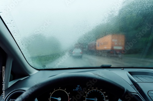 Intense traffic on the highway on a foggy rainy day. Raindrops on the windshield. Ascent of the mountain on the Imigrantes highway