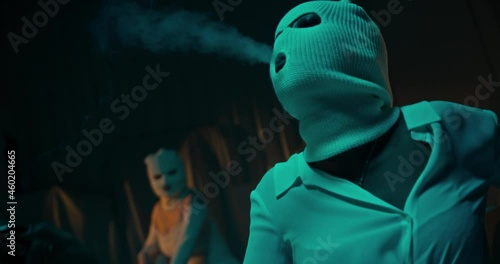 A sexy criminal woman wearing a white facemask and smoking a cigarette in a dark room shot in 4K photo