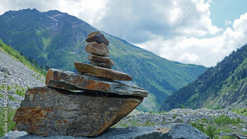 Canvas Print Closeup of stacked rocks surrounded by mountains covered in greenery in the coun