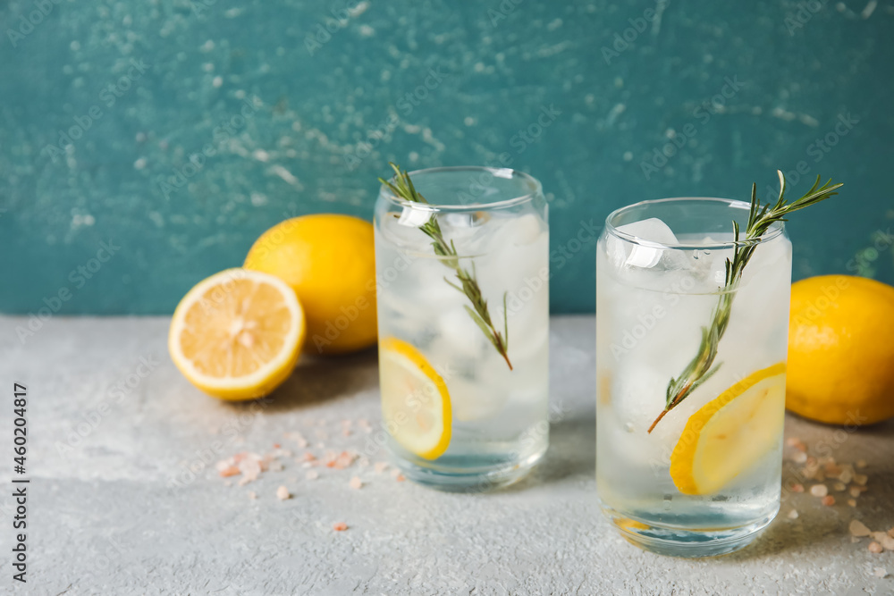 Glasses of cold gin tonic on color background