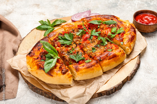 Wooden board with tasty Turkish Pizza on light background