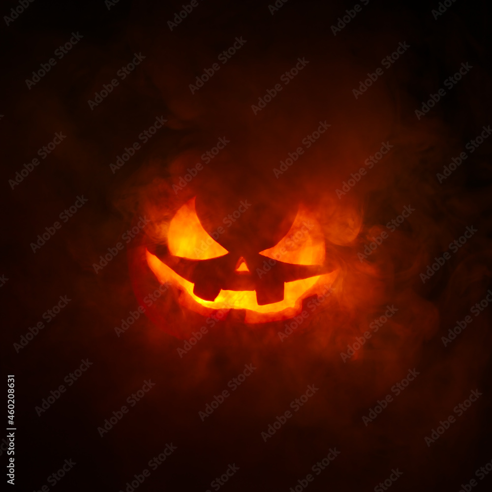 Spooky carved Jack o Lantern glowing a fiery red with thick smoke poring out of the face with a scary evil grin. Spooky carved Jack o Lantern glowing a fiery red with thick smoke poring out of the face with a scary evil grin.