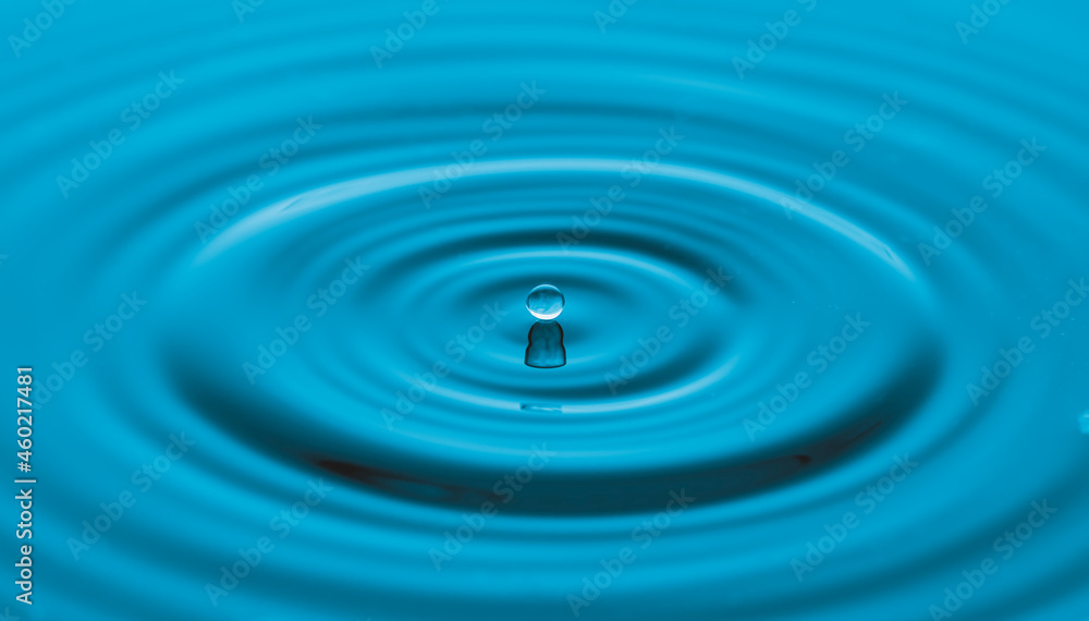 Water drop on water surface with blue light effects background. Water drop on water surface with blue light effects background.
