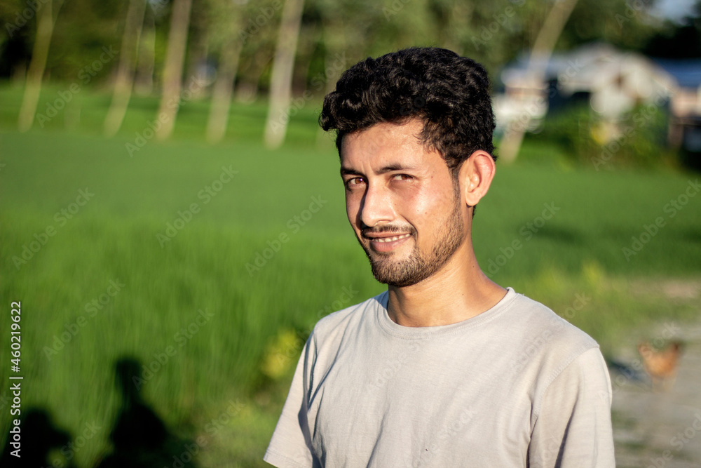 A handsome boy is standing on a sunny day and his small beard And stared with curved eyes and behind the background blur. A handsome boy is standing on a sunny day and his small beard And stared with curved eyes and behind the background blur.