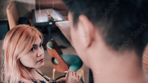 A young woman looks at an strange man approaching her. Attempted pickup line or forgotten acquaintance.