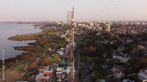 Antenna for communications in municipality of Vicente Lopez near Plata River at sunset, Buenos Aires in Argentine. Aerial circling photo