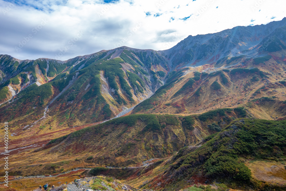 Fototapeta premium 富山県立山町の立山の秋の紅葉の季節に登山している風景 Scenery of climbing Tateyama Mountain in Tateyama Town, Toyama Prefecture, Japan during the season of autumn leaves. 