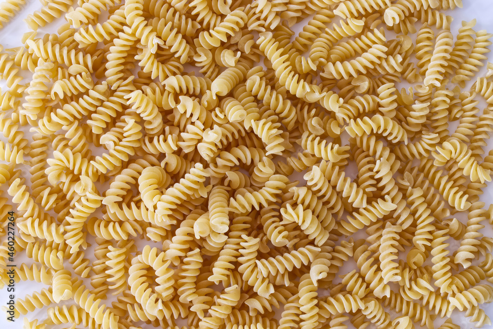 Raw Fusilli Pasta on the floor background. Traditional Italian cuisine. View from above Raw Fusilli Pasta on the floor background. Traditional Italian cuisine. View from above