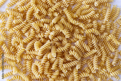 Raw Fusilli Pasta on the floor background. Traditional Italian cuisine. View from above