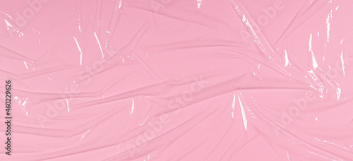 Foto Crumpled wrinkled plastic transparent plastic cellophane on light pink color background