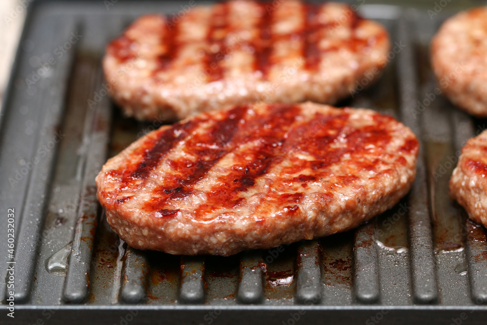 Electric grilled cutlets. Close up beef or pork meat barbecue burgers for hamburger prepared grilled.