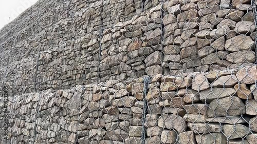 Gabion wall constructed using steel wire mesh basket. Stone walls, protection from backshore erosion. Gabion and rock armour-coastal and waterways protection photo
