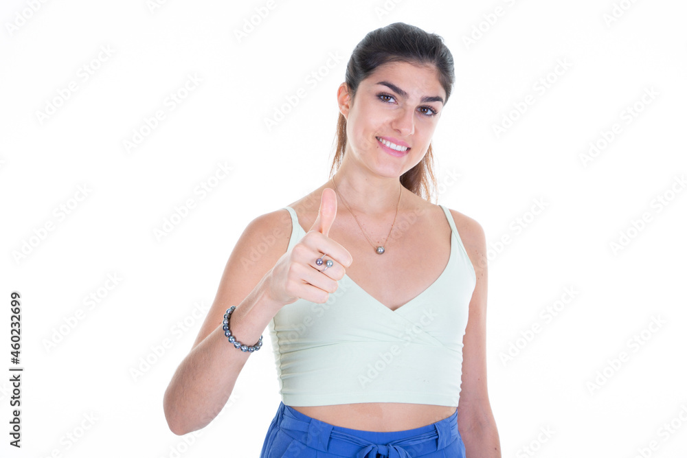 Young woman portrait giving thumb up aside white copy space background Young woman portrait giving thumb up aside white copy space background