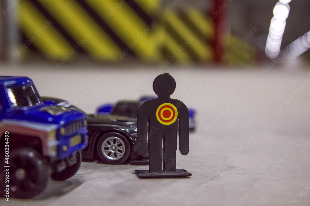 Fototapeta premium Toy car models and human's figure in a parking place in a residential building. Covered underground parking for cars