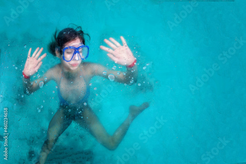 Defocused image. Girl snorkeling in a blue water with circles and ripples. A backdrop of the sea and ocean depth with copy space. Drowning concept