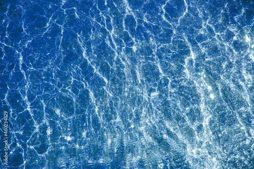 Blue water and pouring mica through a layer of glitter water. A backdrop of the sea and ocean depth