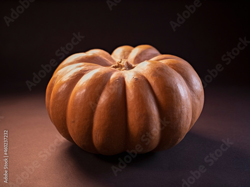 Pumpkin close-up on a black background in isolation. Soft mystical lighting with highlights, flare, flicker in the frame. Autumn theme. The holiday of Halloween.