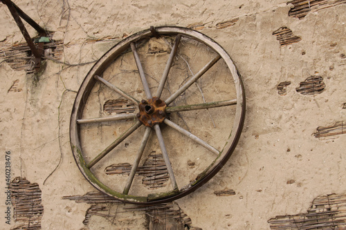 Altes Wagenrad an einer alten Wand