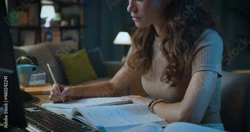 Smart young woman studying late at night photo