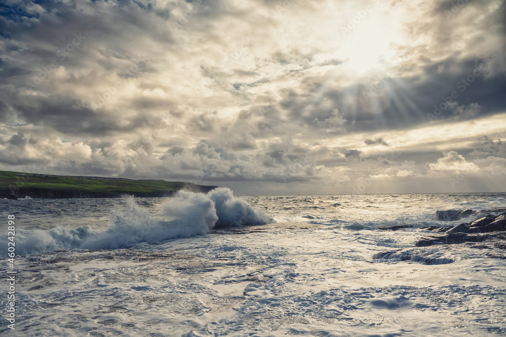 Powerful ocean waves hit rough stone coast. Doolin, county Clare, Ireland. Dark dramatic light and cloudy sky. Irish landscape. Power of nature concept. Dramatic image Powerful ocean waves hit rough stone coast. Doolin, county Clare, Ireland. Dark dramatic light and cloudy sky. Irish landscape. Power of nature concept. Dramatic image