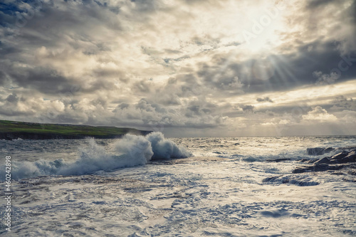Powerful ocean waves hit rough stone coast. Doolin, county Clare, Ireland. Dark dramatic light and cloudy sky. Irish landscape. Power of nature concept. Dramatic image © mark_gusev